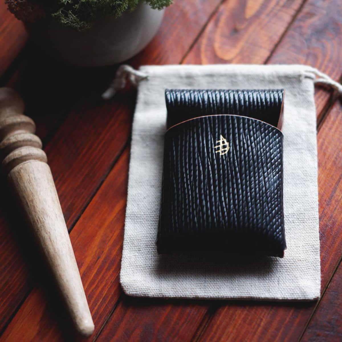 Tabletop view of The Mini Lodgepole Stitchless Wallet in Black Metta Catharina Shell leather
