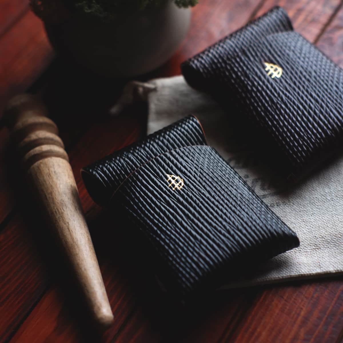 Two Mini Lodgepole Stitchless Wallets in Black and Cognac Metta Catharina Shell leather side by side