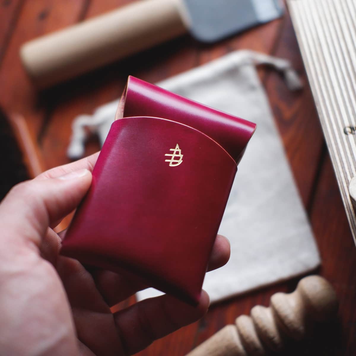The Mini Lodgepole Stitchless Wallet in Pink Marbled Shell Cordovan leather held in hand