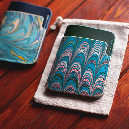 Tabletop view of The Vertical Card Holder in Green Buttero and hand dyed marbled vegetable tanned leather