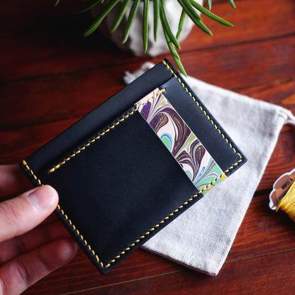 The Executive Card Wallet in Black Graffiti and hand dyed marbled vegetable tanned leathers - front, held in hand