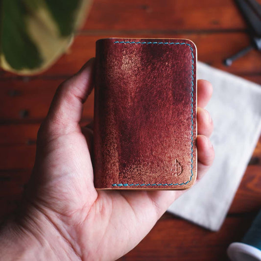 The Monterey Slim Bifold wallet in Mogano Appaloosa leather held in hand