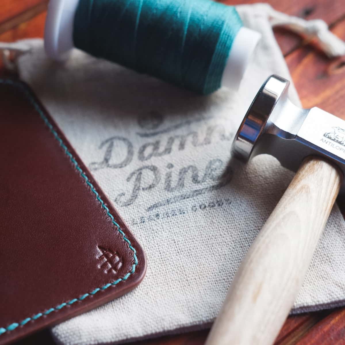 Close up scene of The Monterey Slim Bifold, the blue thread and thread hammer