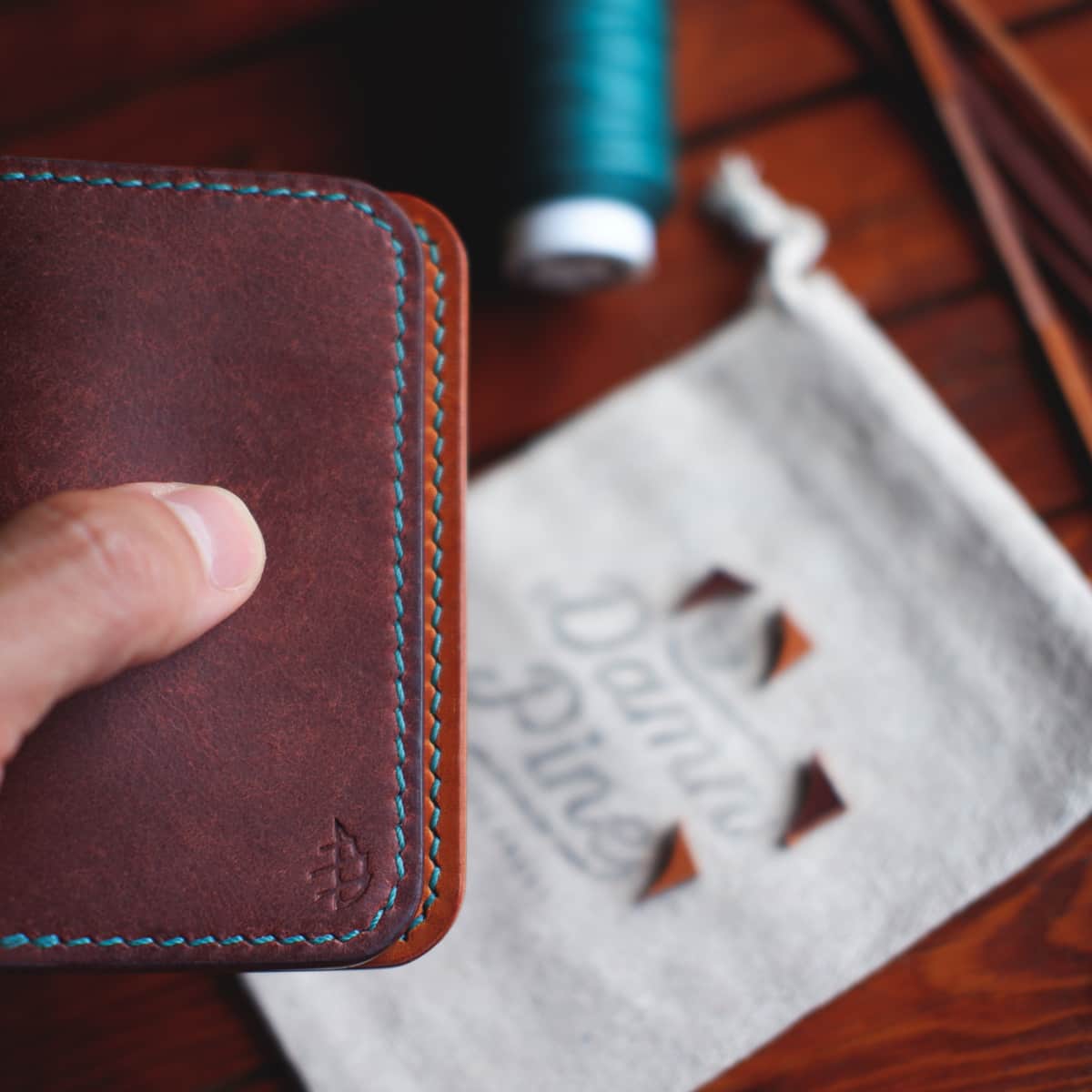 The Monterey Slim Bifold in Graffiti vegetable tanned leather held in hand