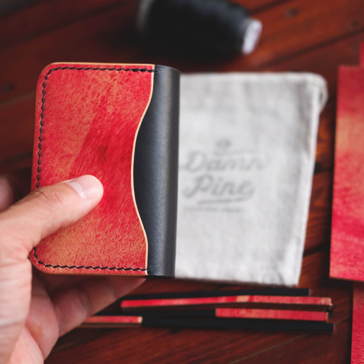 The Monterey 3-Slot Bifold wallet held in hand