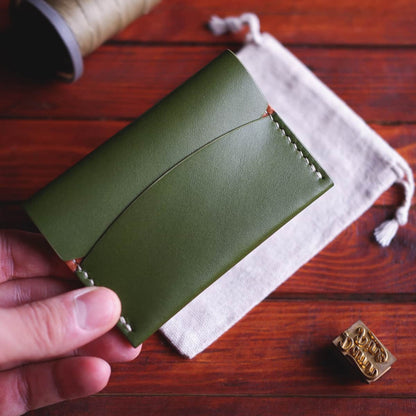 The Mountain Card Wallet in Koala leather - front, closed, held in hand