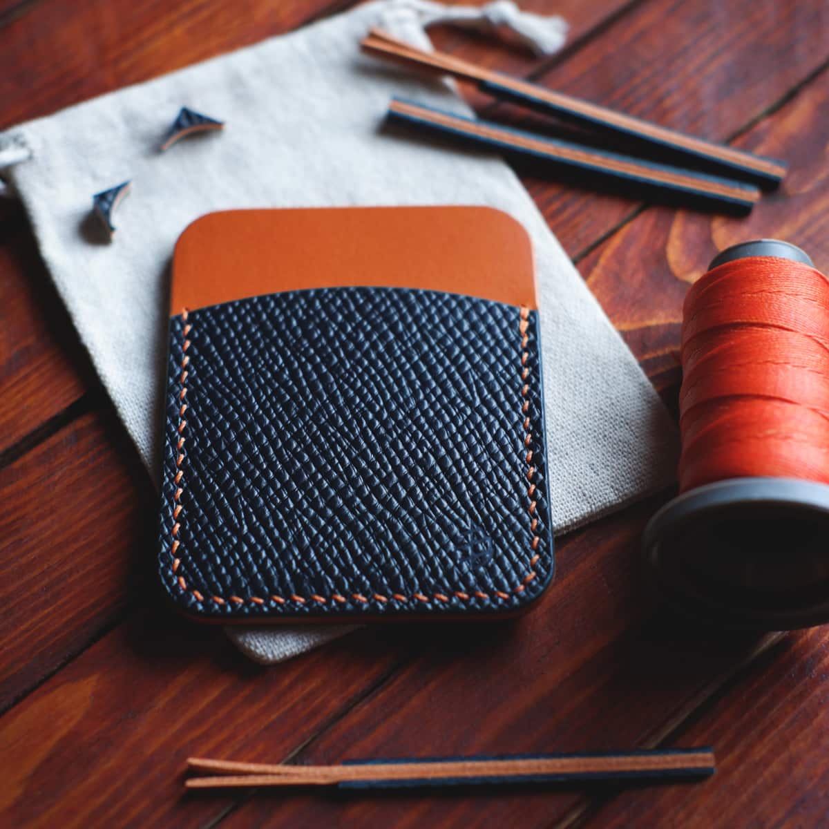 Tabletop view of The Palm Card Holder in Blue Buttero Hatch and Orange Koala vegetable tanned leathers