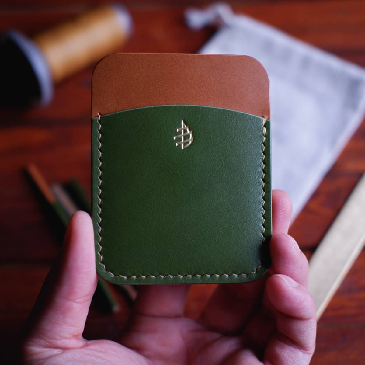 The Palm Card Holder with gold foil stamped Damn Pine logo held in hand
