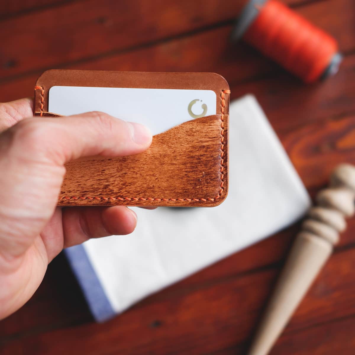 The Pinyon Card Holder in Brown Appaloosa and Whiskey Maya vegetable tanned leather held in hand