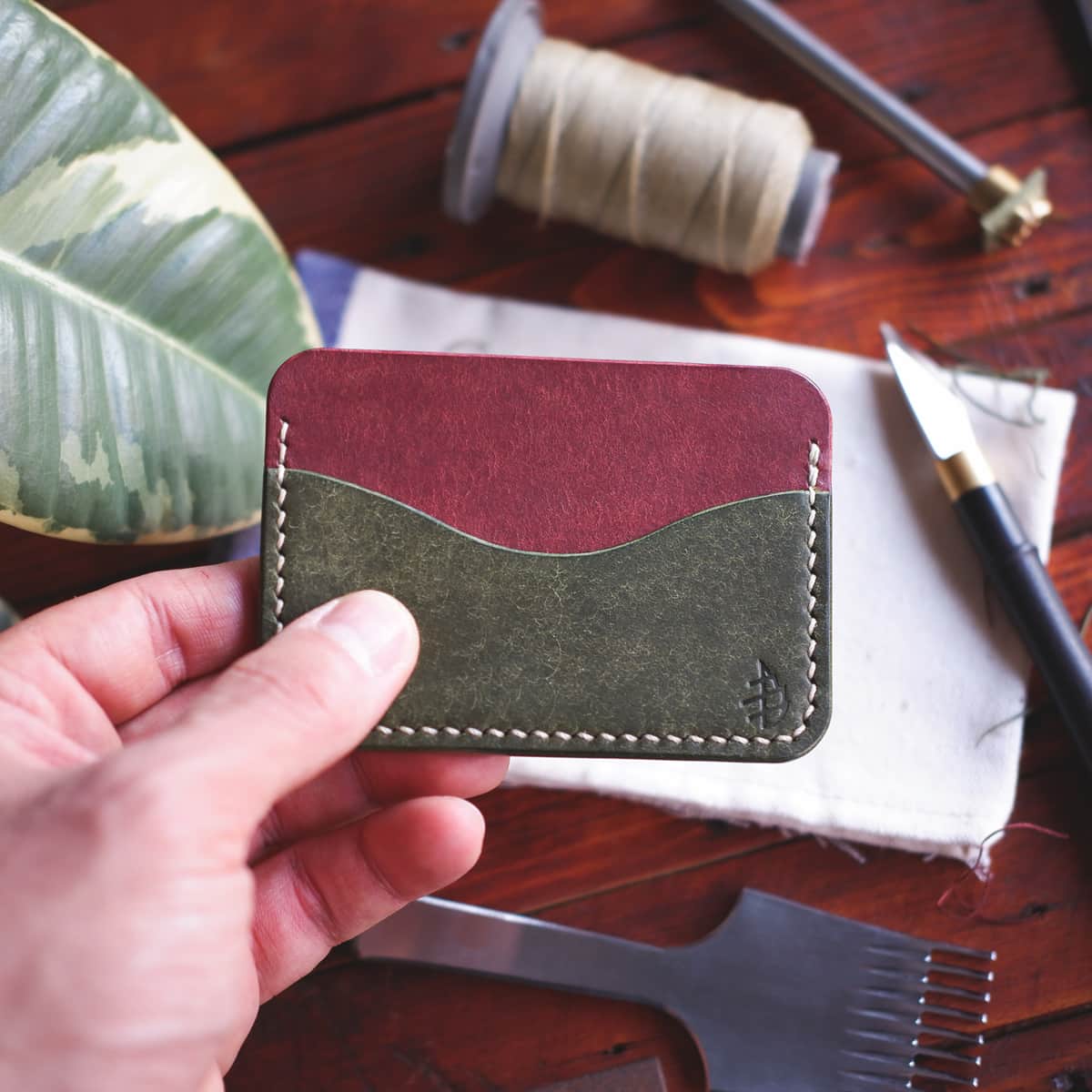 The Pinyon Card Holder in Coccinella and Olive Pueblo vegetable tanned leather held in hand