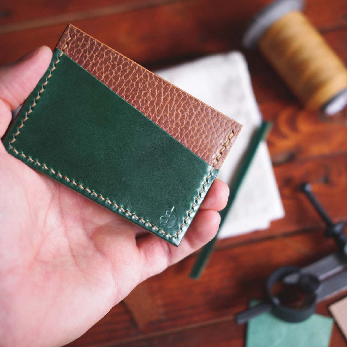 The Scots Card Holder in Emerald Green Gaucho Oil and Brown Dollaro vegetable tanned leather held in hand