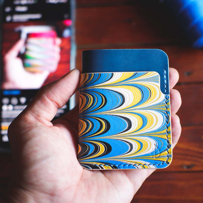 The Vertical Card Holder in Italico Tirreno and hand dyed marbled vegetable tanned leather held in hand